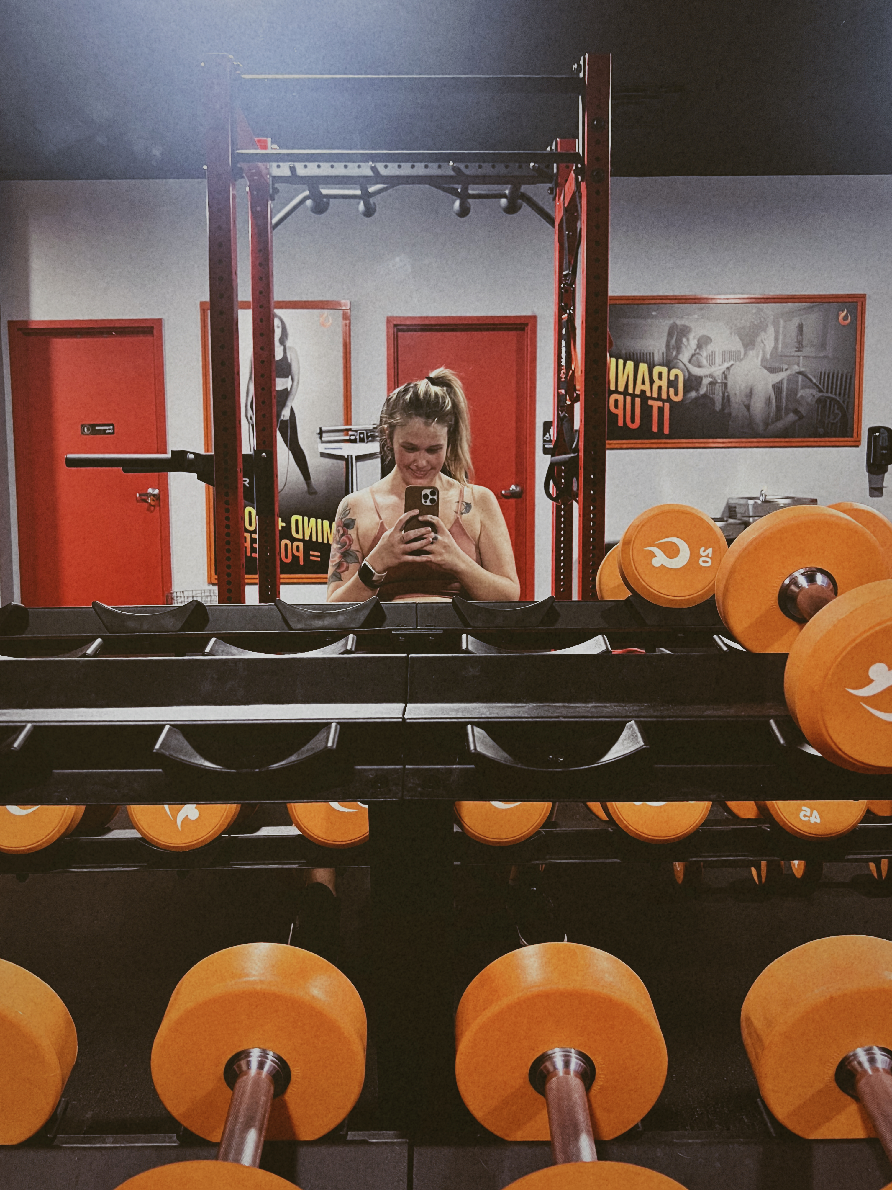 Girl in the gym, excited about weights - 6 steps to stay motivated on your fitness journey