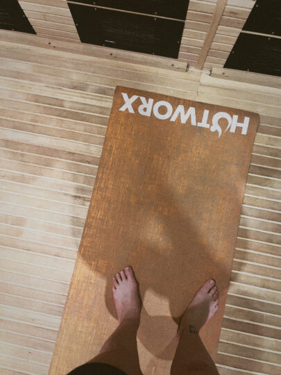 A girl is on the mat of the HotWorx sauna studio.